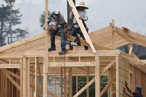 Les travailleurs de la construction construisent une nouvelle maison sur une propriété qui a brûlé dans l'incendie d'Eaton le 15 août 2025 à Altadena, en Californie.