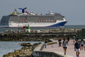 Un bateau de croisière dans la mer près d'une passerelle avec des gens qui marchent dessus