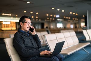 Un homme parle au téléphone dans un aéroport.