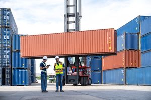 Travailleurs avec des conteneurs maritimes