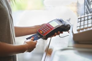 Femme payant avec un terminal de carte de crédit