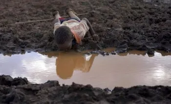 enfant buvant de l'eau sale