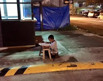 Un garçon philippin sans abri étudie sous la lumière d'un McDonald's